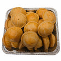 Aluminum tray filled with small round pies on a white background