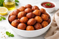 Bowl of fried puff puff items on a table with condiments and lemon.