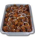 Aluminum tray with cooked turkey and onions on a white background