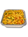 A square aluminum foil pan filled with cooked penne pasta mixed with sliced zucchini, carrots, and other vegetables, isolated on a white background.